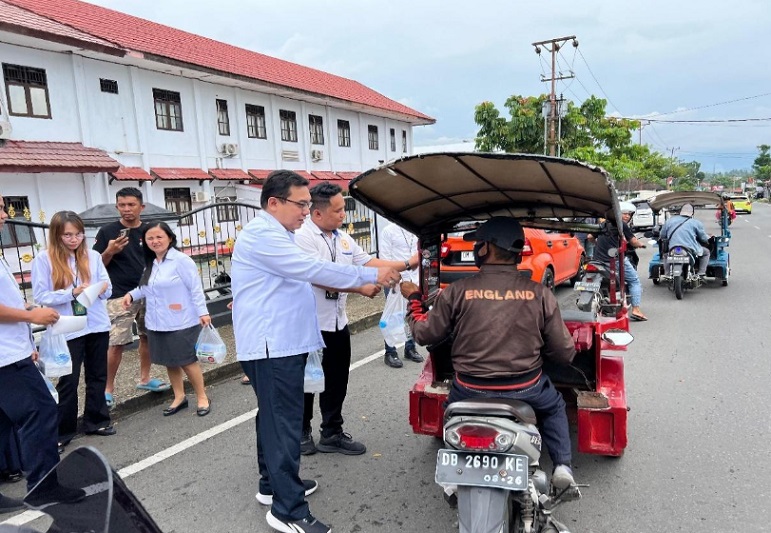 Ketua 
Pengadilan Negeri Kotamobagu membagikan takjil pada salah satu transportasi umum. Foto Pengadilan Negeri Kotamobagu