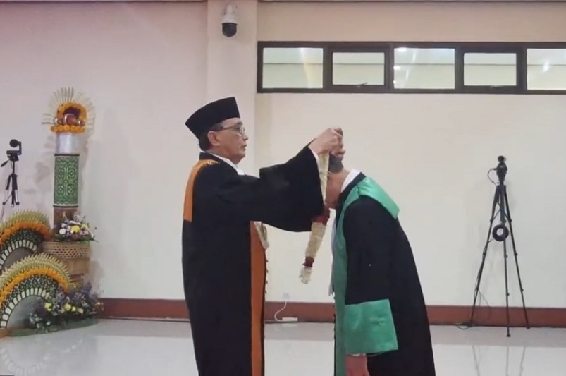Ketua Mahkamah mengalungkan kalung bunga kepada KPTA Bali pada Wisuda Purnabakti. Foto: Youtube MA