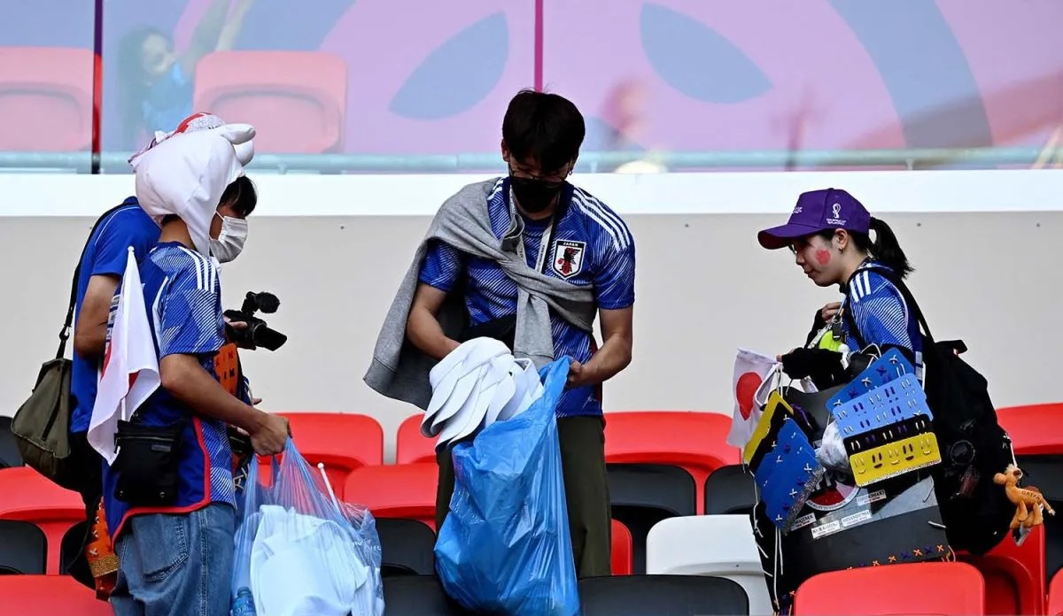 Suporter timnas Jepang membersihkan sampah di tribun penonton usai laga grup E Piala Dunia 2022 melawan Kosta Rika di Ahmad Bin Ali Stadium, Al Rayya, Qatar, Minggu (27/11/2022). Antara Foto/ Reuters/Dylan Martineez/Aww