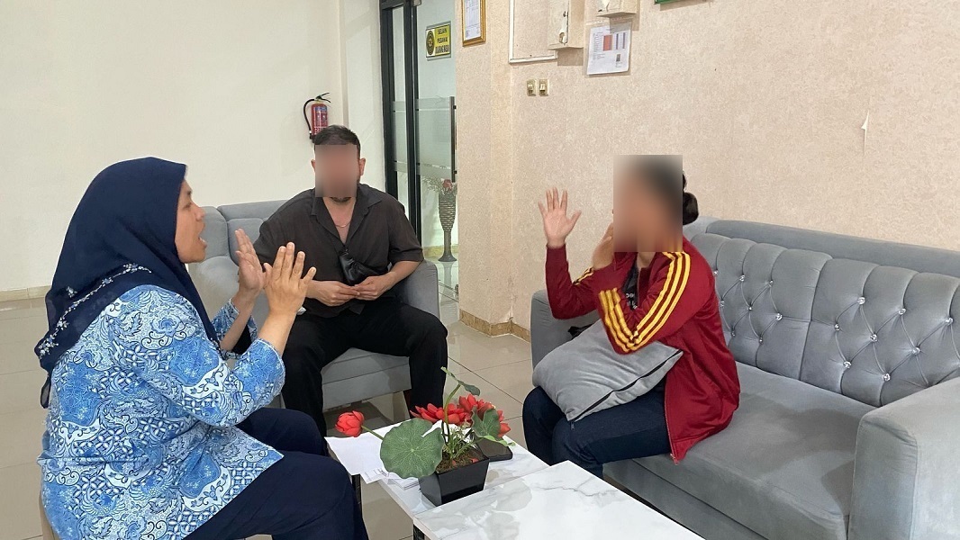 Pegawai Pemerintah Non Pegawai Negeri (PPNPN) Meicy Masyitoh, A.Md. (baju batik) memberikan pelayanan inklusif dan ramah disabilitas bagi pihak berperkara di Pengadilan Agama Jakarta Timur. Foto dokumentasi PA Jakarta Timur